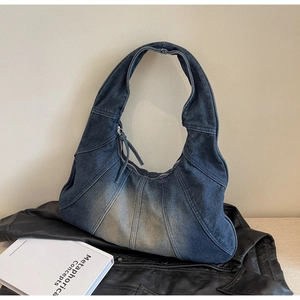 Detailed view of high-density denim patchwork shoulder bag with silver tassel zipper