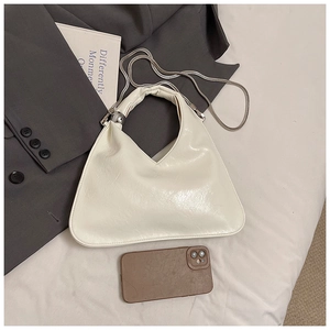 Elegante borsa a mano in pelle color crema con dettagli argentati e tracolla a catena