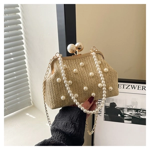 Detailed view of woven straw evening bag with scattered pearls and elegant pearl handle