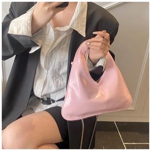 Dettaglio della borsa a mano in pelle verniciata rosa con manico integrato lucido