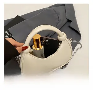 Detail view of white crescent bag interior fitting a smartphone and perfume bottle