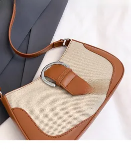 Detail of cream woven fabric and brown leather bag with silver horseshoe buckle