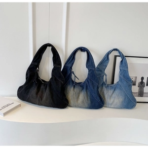 Three denim hobo bags in black, dark blue and light blue on a minimalist display