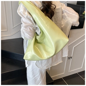 Gros plan sur le sac à bandoulière vert clair brillant montrant la texture du cuir