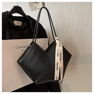 Détail du sac cabas plissé noir avec ouverture en V et ruban élégant sur la lanière