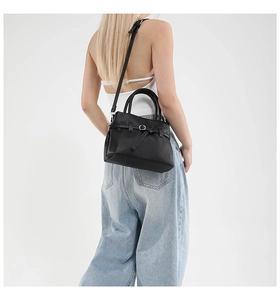 Detailed view of the black lychee pattern leather handbag showing fine texture and strap