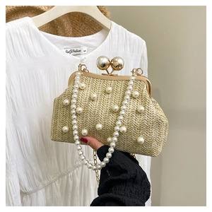 Detail of hand-woven straw evening bag with large pearl clasp and pearl bead strap
