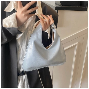 Dettaglio borsa tote in pelle verniciata azzurra con sfera d'argento e catena