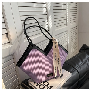 Détail du cabas plissé violet avec bordures en cuir noir et ruban décoratif