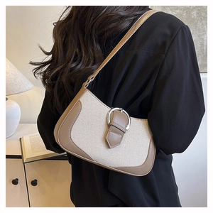 Close-up of retro canvas and brown leather underarm bag with metal horseshoe buckle detail