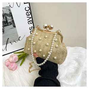 Detail of hand-woven straw bag featuring pearl embellishments and a gold clasp
