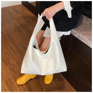Détail d'un grand sac cabas blanc en cuir verni brillant pour les déplacements quotidiens