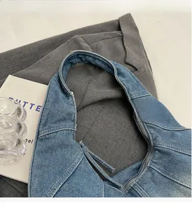 Detail of blue denim stitching and heavy twill texture on a vintage hobo shoulder bag