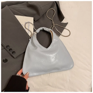 Dettaglio borsa a mano in pelle lucida azzurra con catena d'argento ed eleganza