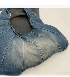 Detailed macro of soft washed denim fabric texture and sturdy metal zipper of the tote bag