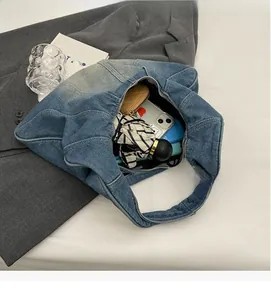 Detail of blue denim tote bag spacious interior showing storage for phone and umbrella