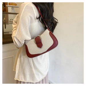 Detail of canvas and brown leather patchwork shoulder bag with silver D-buckle detail