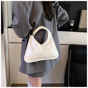 Detail of cream white glossy leather handbag with gold ball link and chain strap
