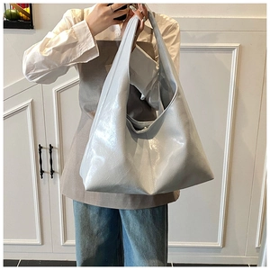 Détail d'un sac cabas argenté métallisé avec texture froissée et anse large