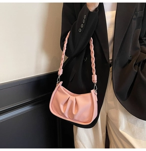 Detail of pink pleated hobo bag with lychee texture leather and woven strap style