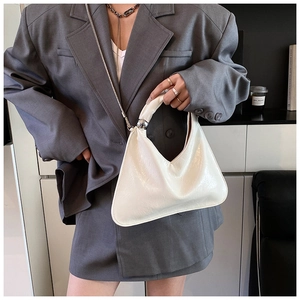 Detail of cream white pleated leather handbag with silver sphere accent and chain strap