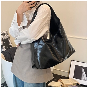 Détail d'un grand sac hobo noir brillant dans un décor de mode minimaliste élégant