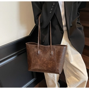 Close-up of vintage brown PU leather tote bag with long handles and matte texture finish