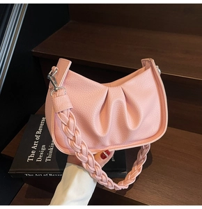 Detail of pink ruched underarm bag with braided strap and silver metal buckle