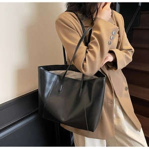 Close-up of a black tote bag showing smooth matte texture and premium gray lining