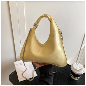 Dettaglio della borsa a mezzaluna giallo chiaro in pelle lucida con chiusura a sfera argento