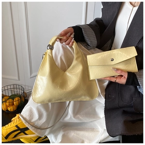 Dettaglio della borsa hobo gialla con portafoglio coordinato e manico con sfera in metallo