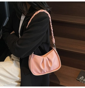 Detailed shot of pink pleated cloud bag with woven strap on lychee leather finish
