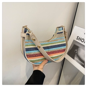 Detail of colorful rainbow striped woven straw handbag with beige leather strap and hardware