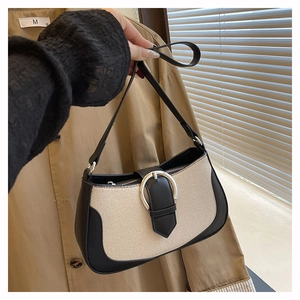 Detail of contrast canvas and leather shoulder bag with silver semi-circular buckle