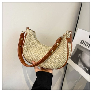 Detail of hand-held beige woven crescent bag with brown leather strap and gold metal buckle