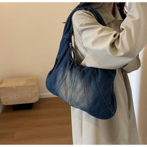 Close-up of vintage patchwork denim hobo bag featuring retro washed blue fabric details
