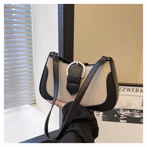 Minimalist ivory canvas shoulder bag with black leather trim and silver metal buckle