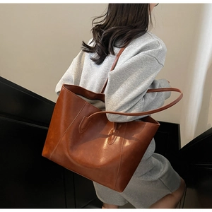Brown retro leather tote bag worn by a model to showcase size and matte texture