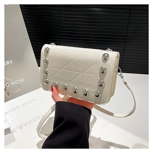 White quilted crossbody bag with silver studs and adjustable strap in a minimalist design