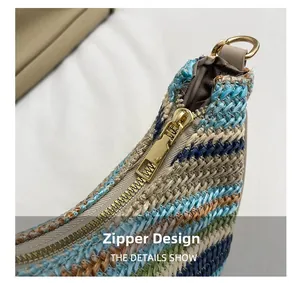 Detailed close-up of the secure gold metal zipper on this striped woven straw shoulder bag