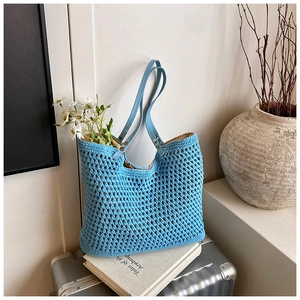 Detail of blue crochet tote bag featuring intricate knit patterns and PU leather straps