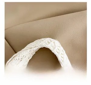 Macro detail of the woven shoulder strap on a cream crochet tote bag showing textile texture