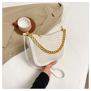 Detail of minimalist woven half-moon bag featuring gold chain and white leather trim