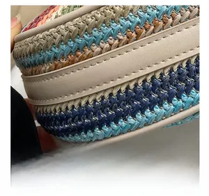 Detail of precise double stitching on beige leather trim of a woven straw bag