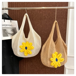 Close-up of hand-woven straw tote bags with large sunflower floral accents and mesh texture
