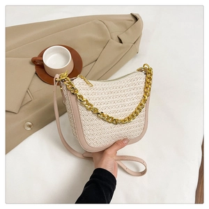 Close-up of beige woven crossbody bag with chunky gold chain handle and zipper detail