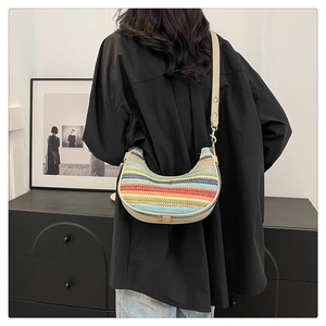 Close-up of rainbow striped woven crossbody bag with adjustable leather shoulder strap