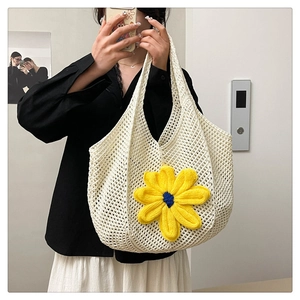 Detail of hand-woven crochet tote bag featuring a vibrant yellow floral accent
