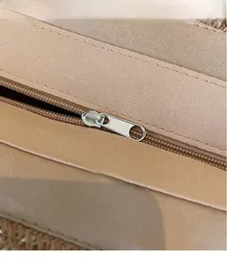 Detailed close-up of the smooth silver hardware zipper puller on a striped woven bag
