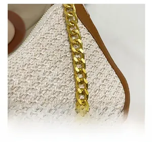 Detail showing the woven texture with leather trim and gold metal chain link on handbag